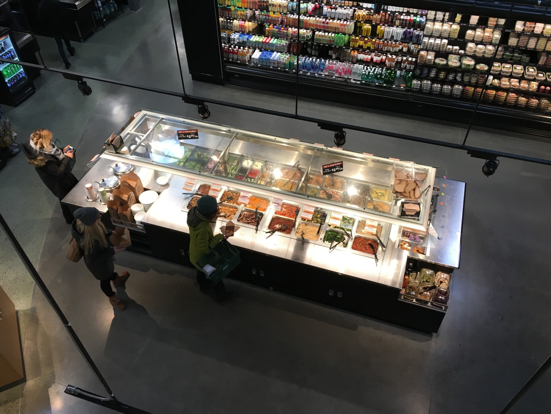 City Market Co-op's deli counter with various food options and customers selecting their meals.