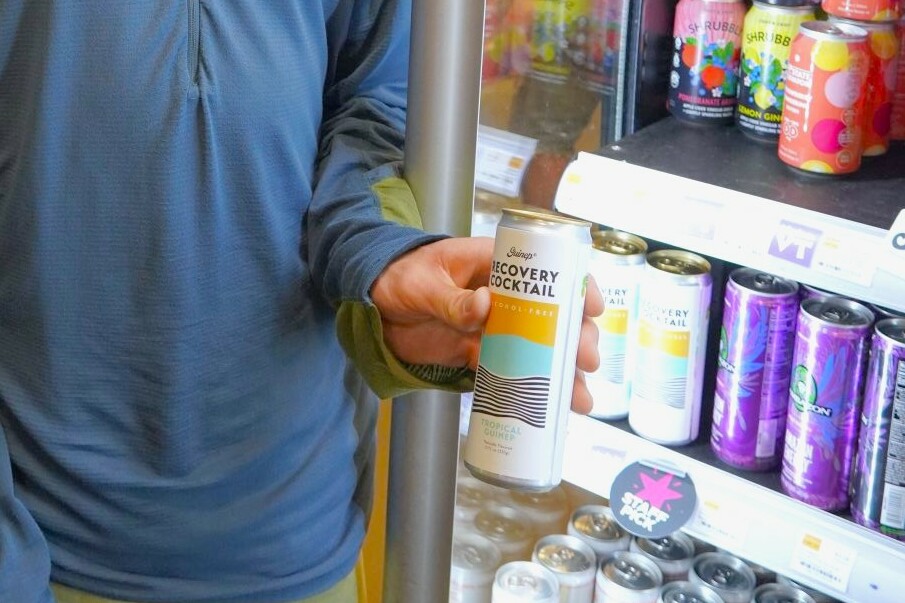 a person holds up a can of guinep
