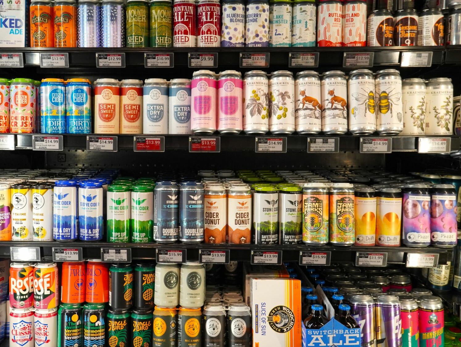 a variety of beer and cider on a grocery store shelf
