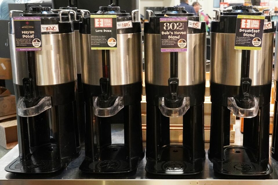 Four coffee dispensers labeled with different blends: Mayan Decaf, Love Buzz, Bob's House, Breakfast Blend.