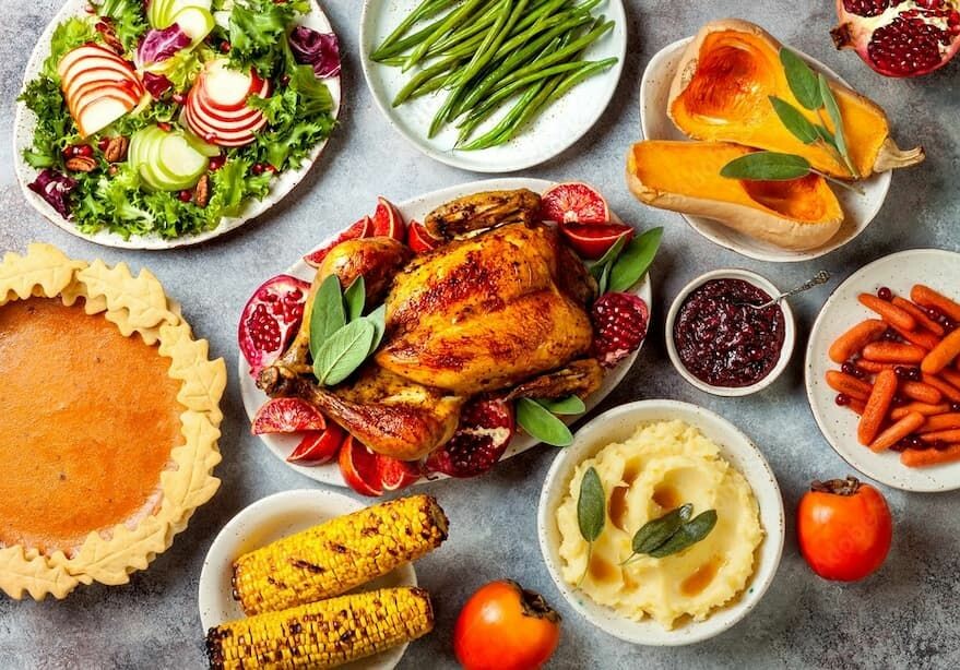 A festive spread featuring roast chicken, mashed potatoes, salad, and various side dishes.