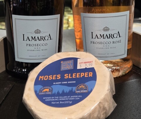 Two bottles of La Marca Prosecco and a wheel of Moses Sleeper cheese.