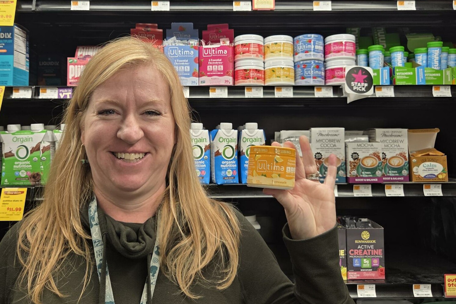 a woman holding up a bottle