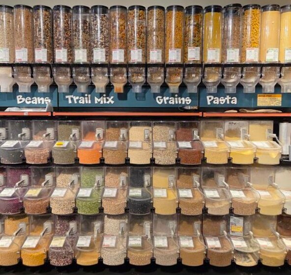Bulk food dispensers showcasing beans, grains, pasta, and trail mix varieties.