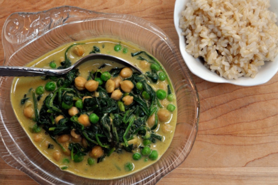 Top down shot of the curry in a clear bowl, next to another bowl of rice.