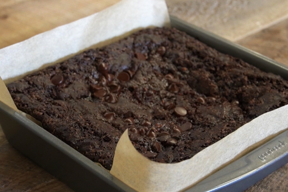 Vegan brownies sit in a pan on a wooden table!