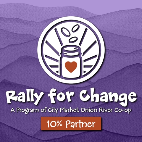 The Rally for Change logo with a white icon depicting a jar with a red heard on the front and three coins falling into it from above. The icon is in front of a mountainous purple watercolor. At the bottom are the words "A program of City Market, Onion River Co-op" and "10% Parner"