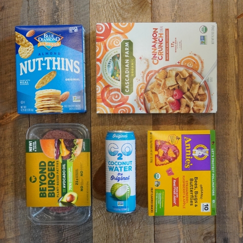 An array of products on sale at the Co-op, including Nut Thins, Cascadian Farms cereal, Beyond Burgers, coconut water and Annie's fruit snacks.