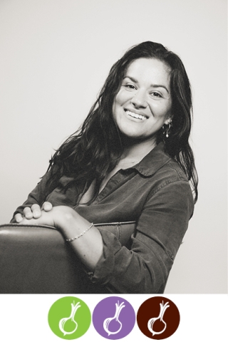 A black and white photo of a woman seated in a chair. She is turned to look out over the back of the chair. She has long dark hair and a dark button-down shirt. She is smiling. Below the photo, three onion silhouettes are arranged in three circles in a horizontal line. The first circle is green, the second is purple and the third is brown.