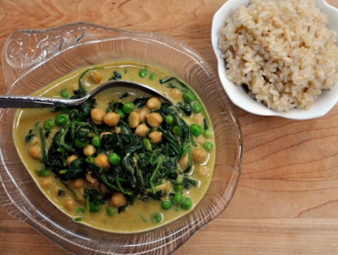 Top down shot of the curry in a clear bowl, next to another bowl of rice. 