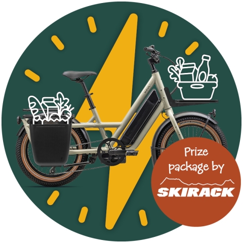 A photo of a light gray e-bike superimposed over a deep green circle with a golden lightning bolt on it. The e-bike has panniers and a front rack. There are drawings of groceries done in white outlines in both baskets. At the bottom right, the words "prize package by Skirack" are printed in white on a rust-red circle with a logo for Skirack.